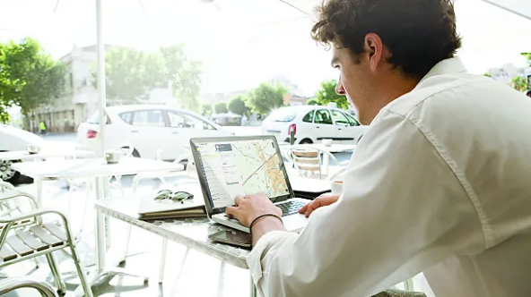Geschäftsmann mit Laptop im Café mit WEBFLEET Software